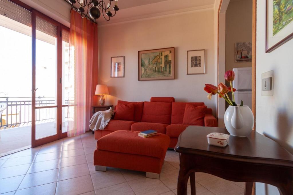 a living room with a red couch and a table at Appartamento TL in Follonica