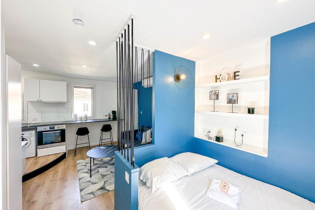 ein blaues Schlafzimmer mit einem Bett und einer Küche in der Unterkunft Studio neuf aux Réformés à 2 min du metro in Marseille