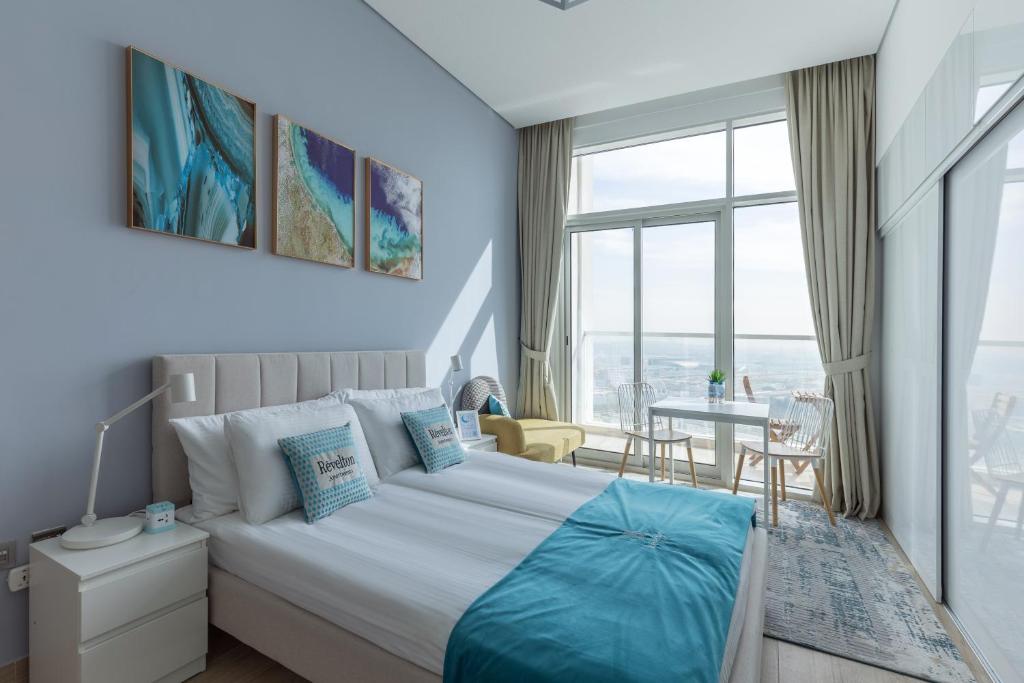 a bedroom with a large bed and a dining room at Revelton Apartment Studio One in Dubai