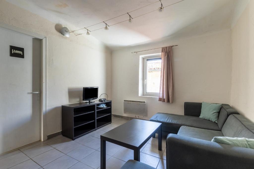 a living room with a couch and a table at Le Beaumier in Cuges-les-Pins