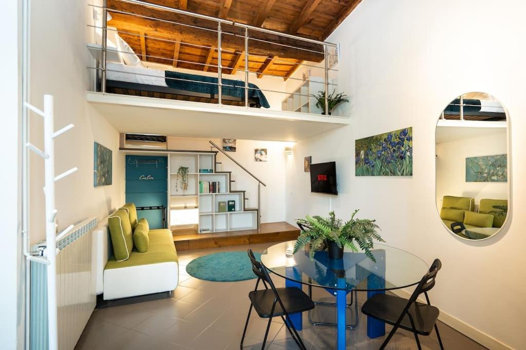 a living room with a glass table and chairs at [DUOMO WALKING DISTANCE] Central Loft in Milan