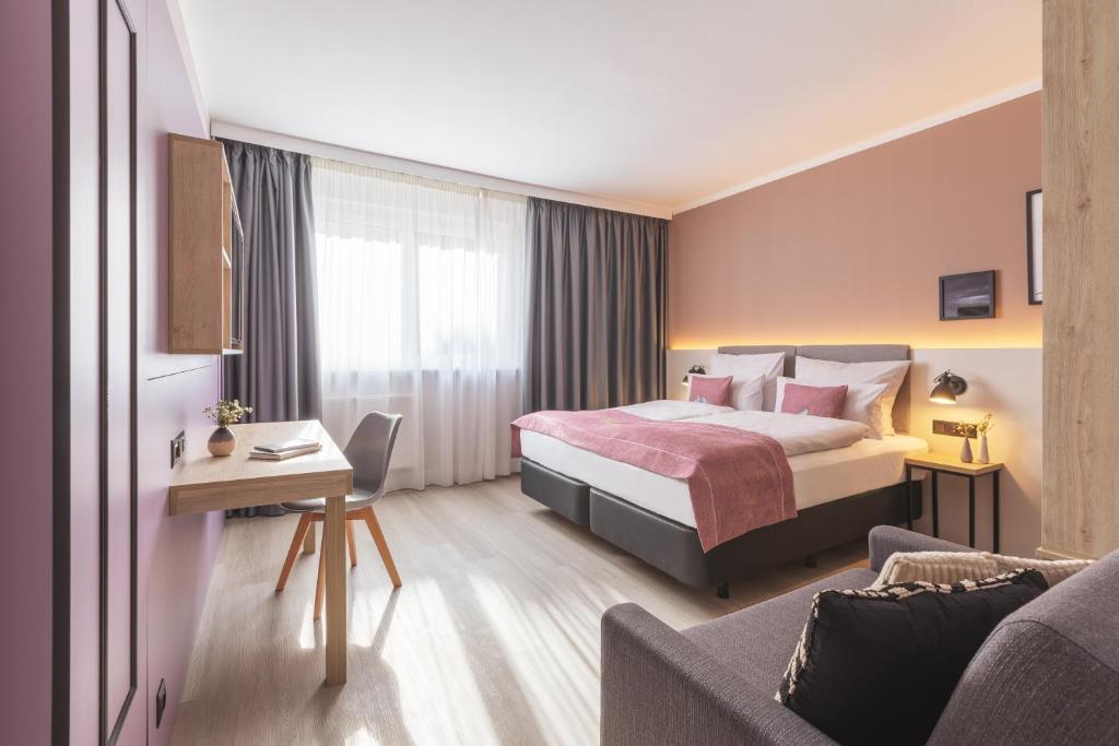ein Hotelzimmer mit einem Bett und einem Sofa in der Unterkunft Yggotel Spurv in Berlin