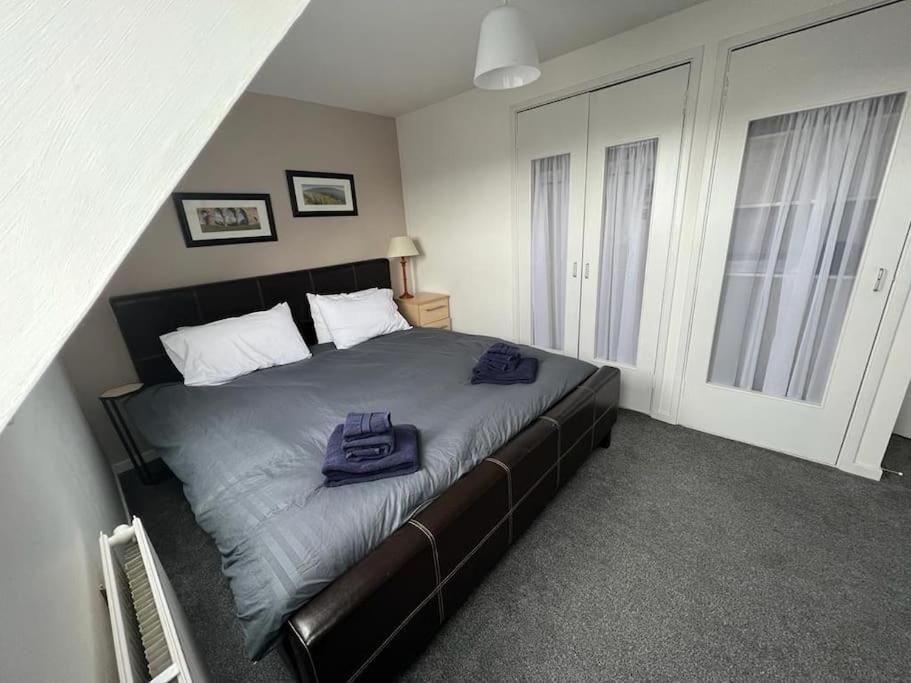 Un dormitorio con una cama con dos bolsas. en Walk to Everything in Crail - Land Sea Cottage en Crail