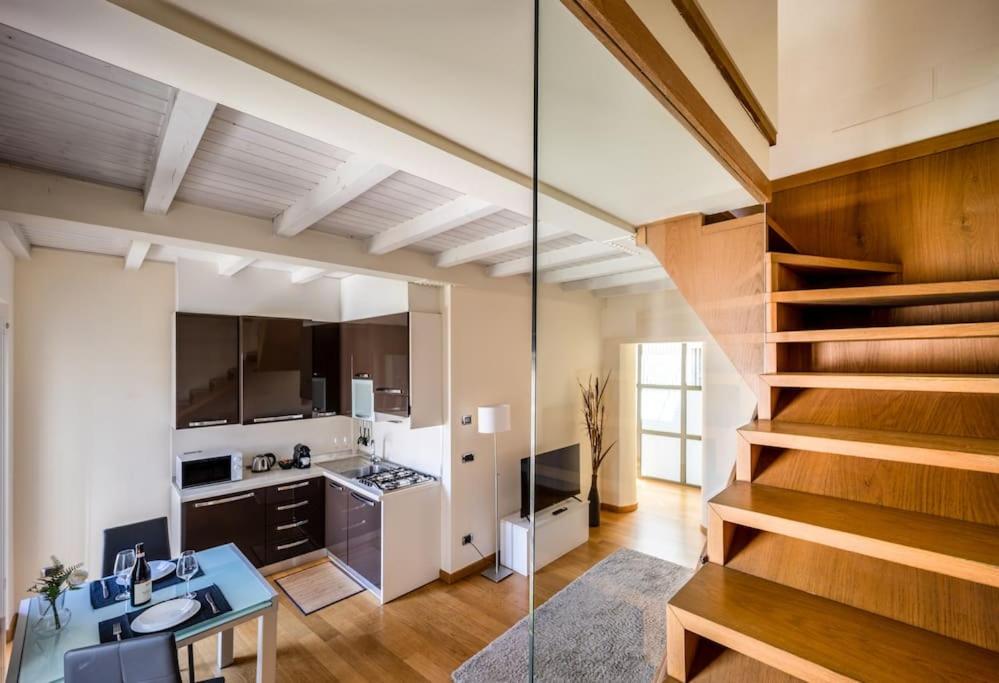 a room with a kitchen and a staircase in a house at [Duomo-Montenapoleone] Elegant and Central Suite in Milan