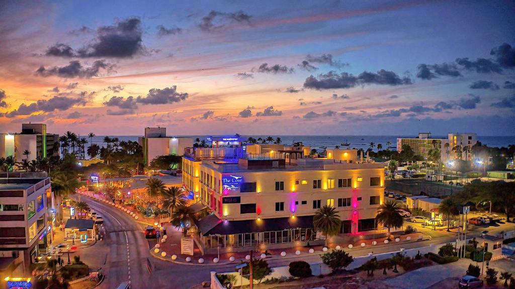 Una ciudad de noche con un edificio y el océano en The Cove - Condo Hotel - Palm Beach Strip, en Palm-Eagle Beach
