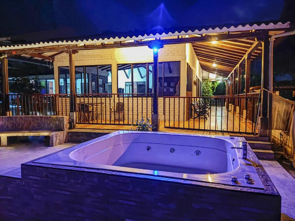 VILLA ALEJANDRA - Hermosa FINCA cerca al centro - Sendero - Jacuzzi في بوبايان: حوض استحمام كبير أمام المنزل في الليل