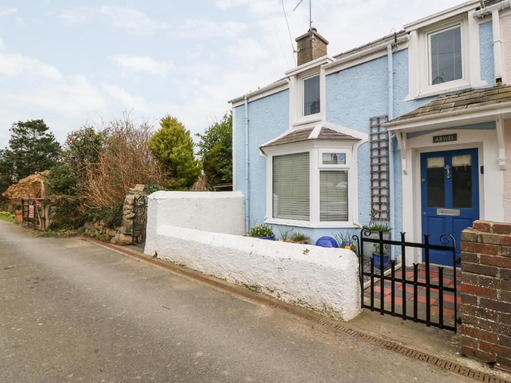 a blue house with a blue door on a street at Arwel in Pwllheli