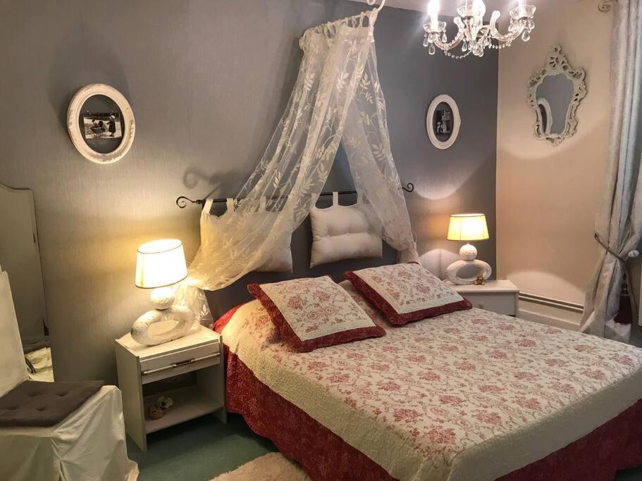 una camera con letto a baldacchino e 2 cuscini sopra di Maison de gardien , manoir de Pichemont, » la maison des écureuils » 