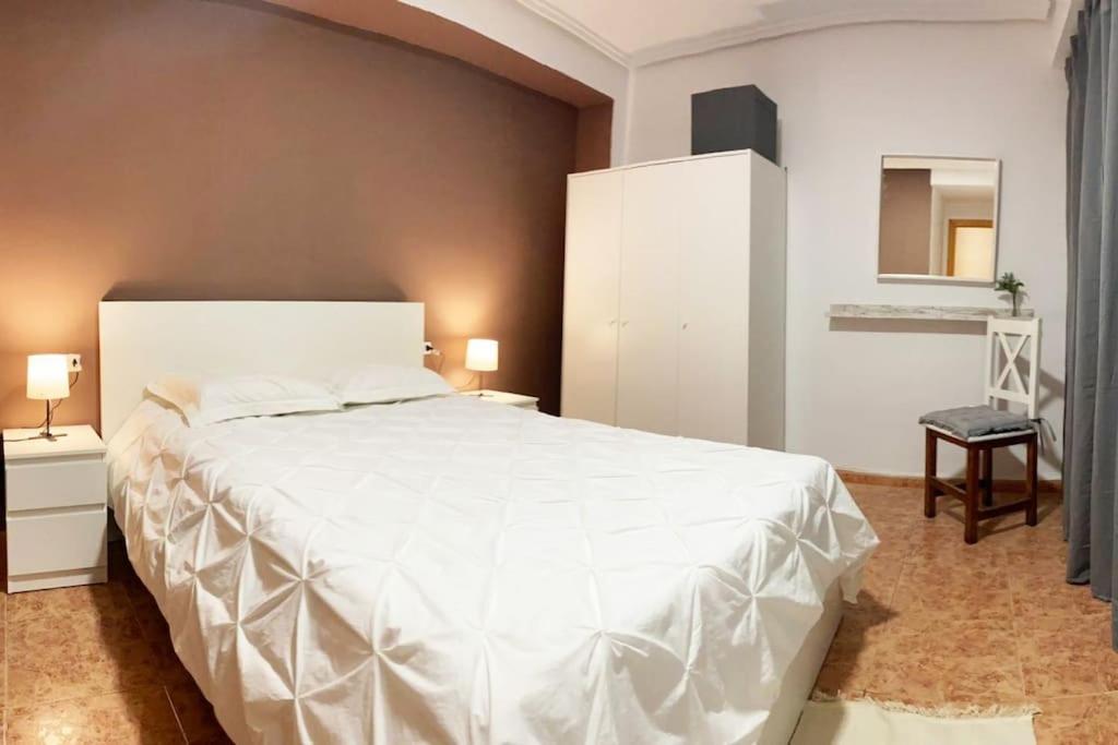 una camera con un grande letto bianco di Rooms in Spacious Beach Flat in Valencia a Valencia
