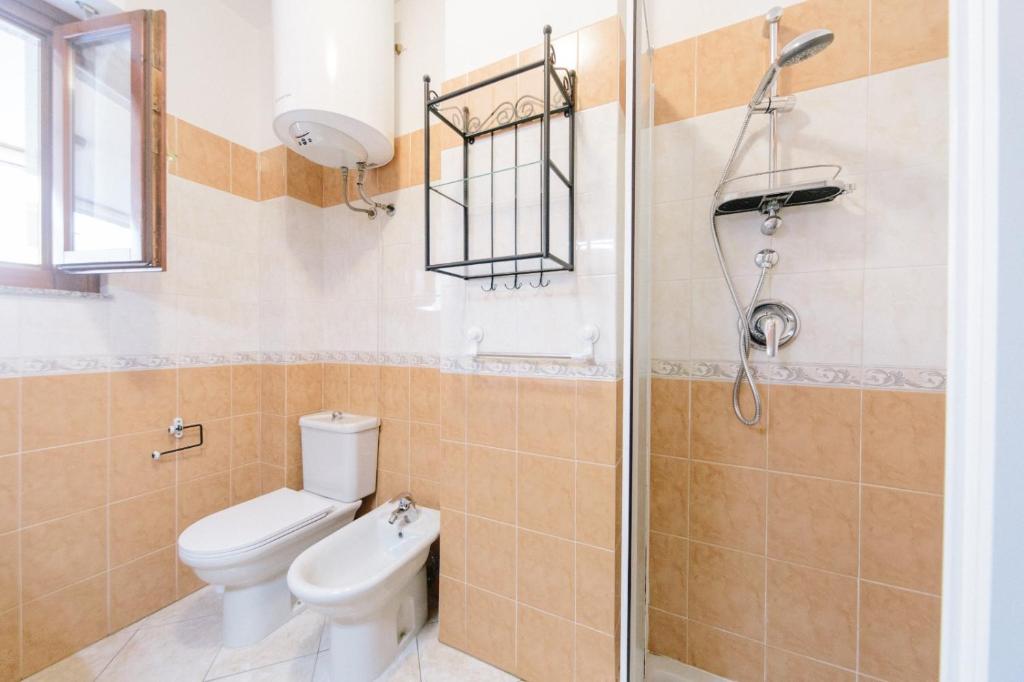 łazienka z toaletą i prysznicem w obiekcie Lido Alghero Beach House w mieście Alghero