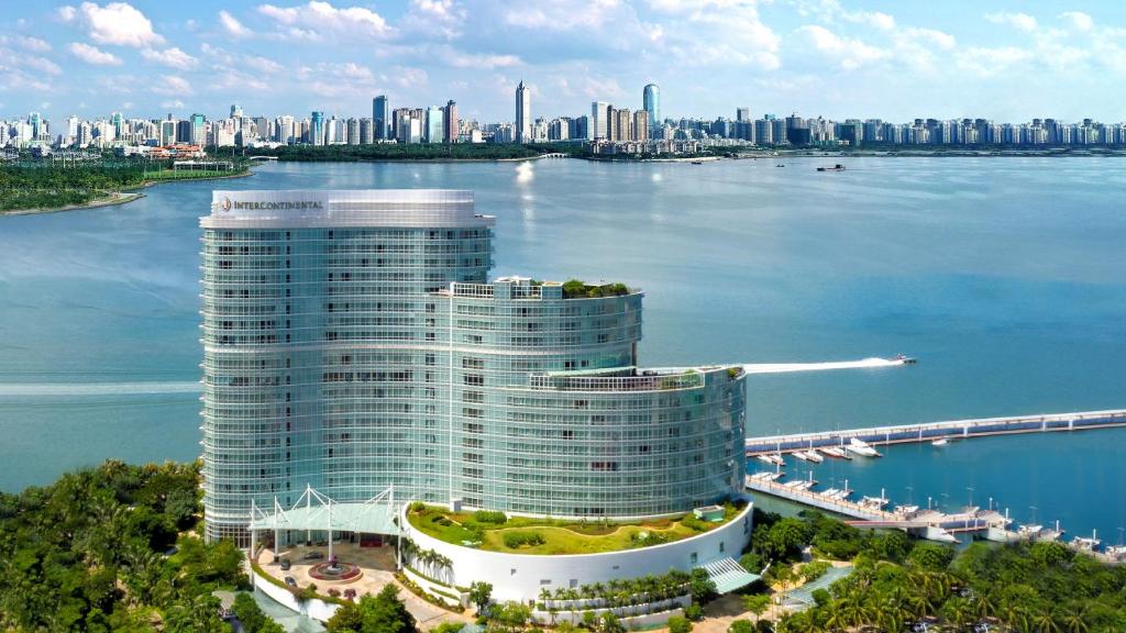 ein hohes Gebäude neben einem großen Wasserkörper in der Unterkunft InterContinental Haikou Seaview, an IHG Hotel in Haikou