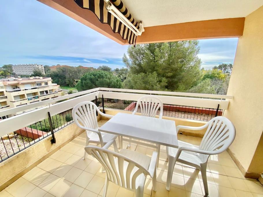 a white table and chairs on a balcony with a view at Appart ESTIVALE pr 4pax Acces plage in Saint-Raphaël