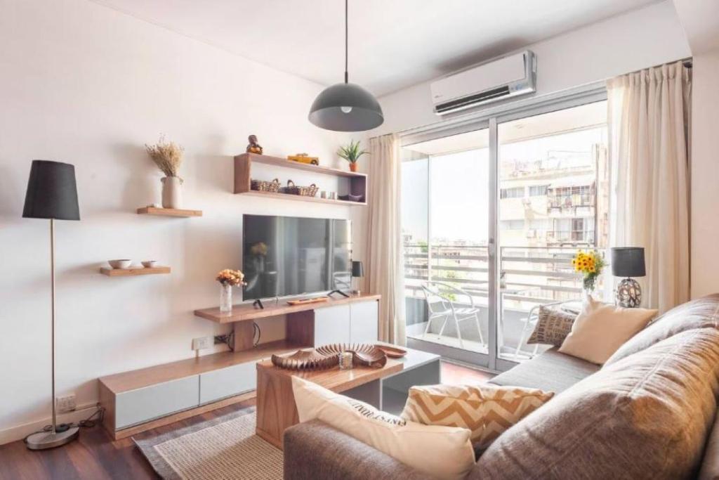 a living room with a couch and a tv at Quartier San Telmo Suites 10 in Buenos Aires