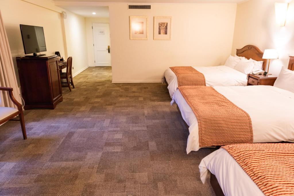 Postel nebo postele na pokoji v ubytování MR Hotel Providencia (ex Hotel Neruda)