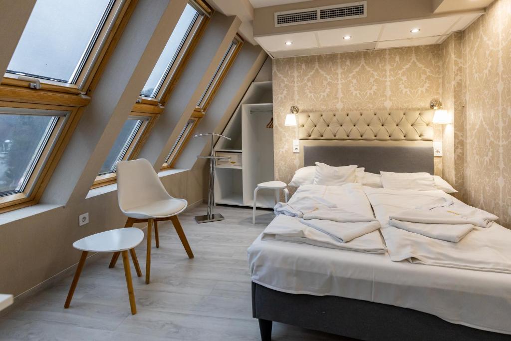 Postel nebo postele na pokoji v ubytování Bástya Konferencia és Wellness Hotel