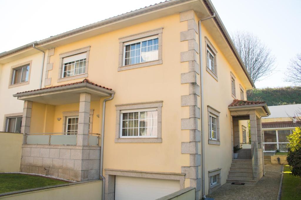 a yellow house with a garage at AM Residence in Braga