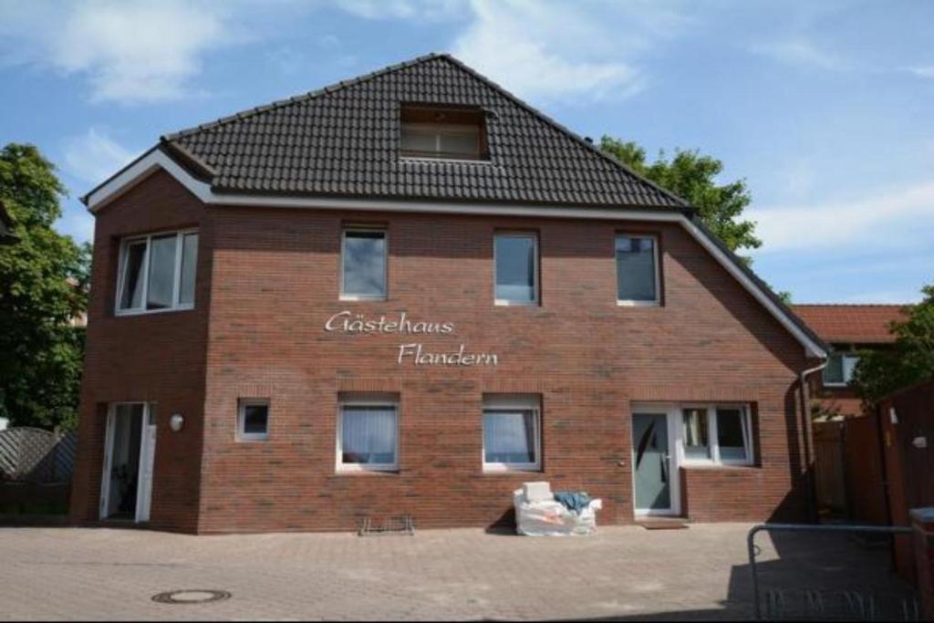 un edificio de ladrillo con un cartel en la parte delantera en Gaestehaus-Flandern-3 en Borkum