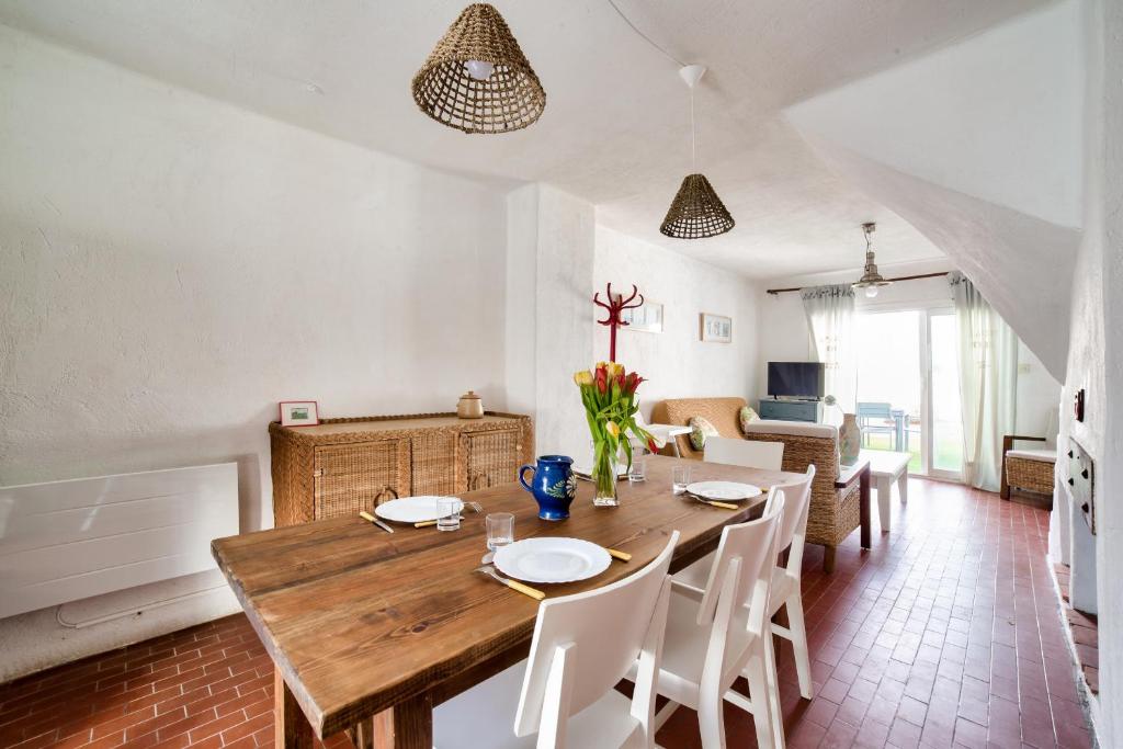 een eetkamer met een houten tafel en witte stoelen bij Maison agreable pour 5 personnes a La Gueriniere in La Guérinière