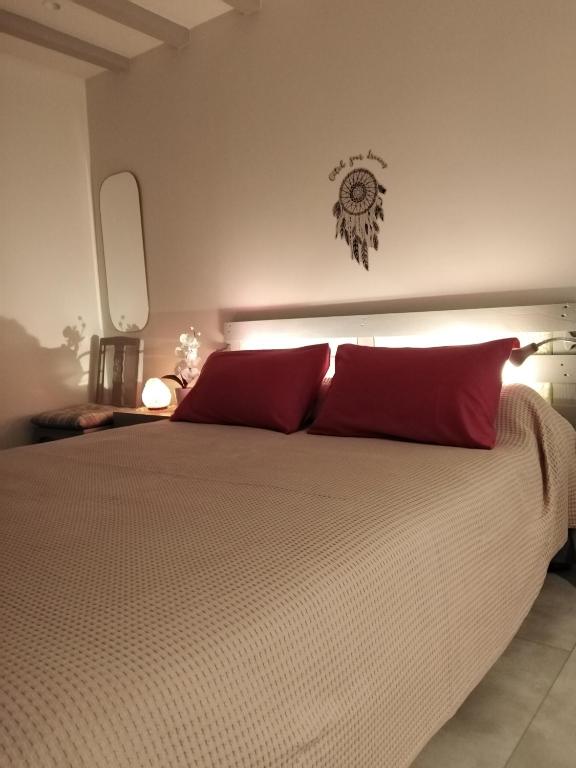 une chambre avec un grand lit avec des oreillers rouges dans l'établissement La Maisonnette de Gallerie, à Cour-Cheverny