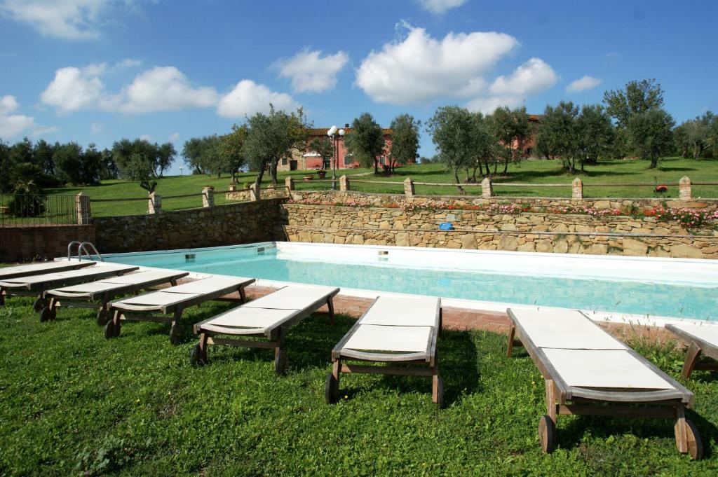 a row of picnic tables next to a swimming pool at Casa Elisabetta in Limite