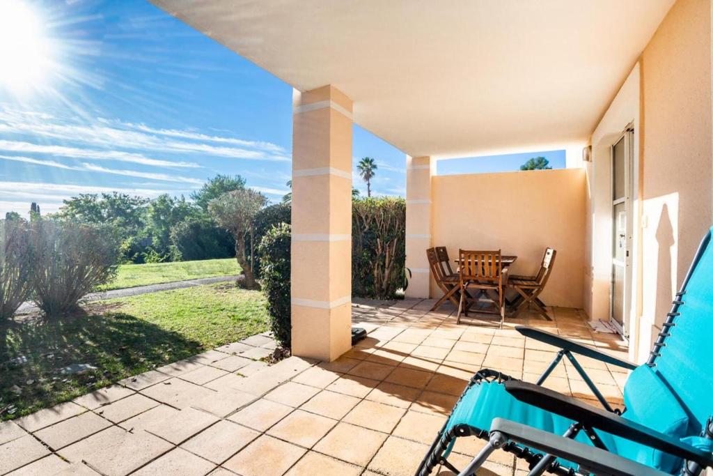 a patio with a table and chairs in a house at Coté Jardin, Villa de Cap Esterel in Saint-Raphaël