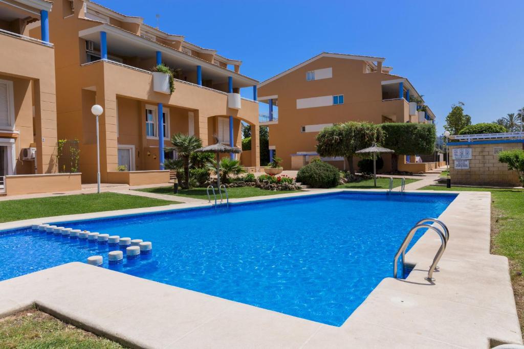 une image d'une piscine en face d'un bâtiment dans l'établissement Menorca Duplex Javea Montanar II by Rock Rentals, à Platja de l'Arenal