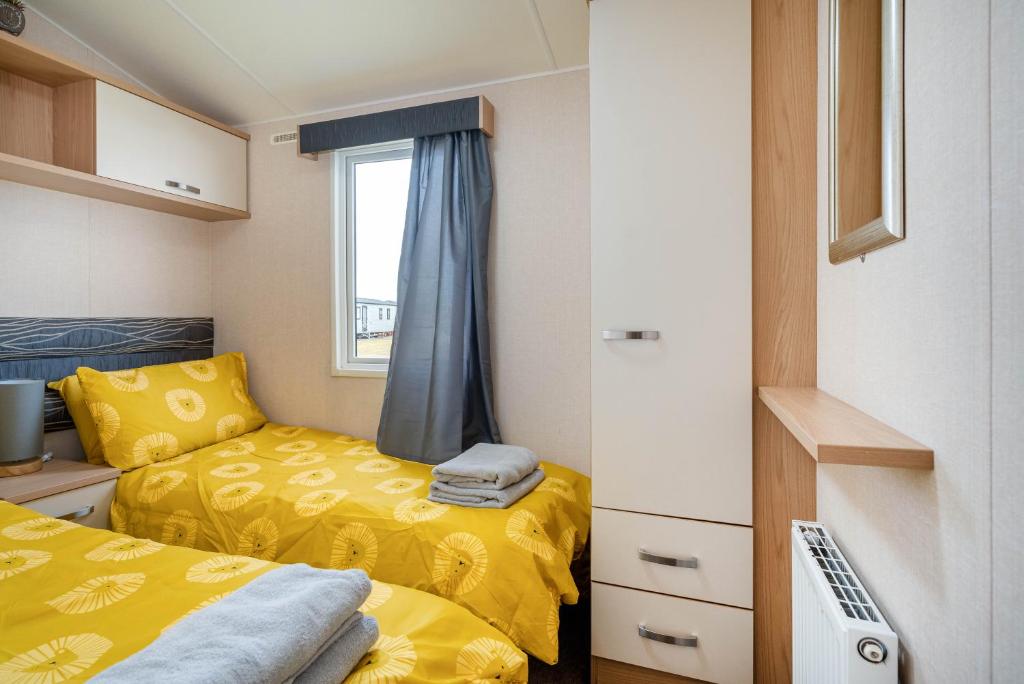 a small bedroom with two beds and a window at Lyons Retreat in Lossiemouth