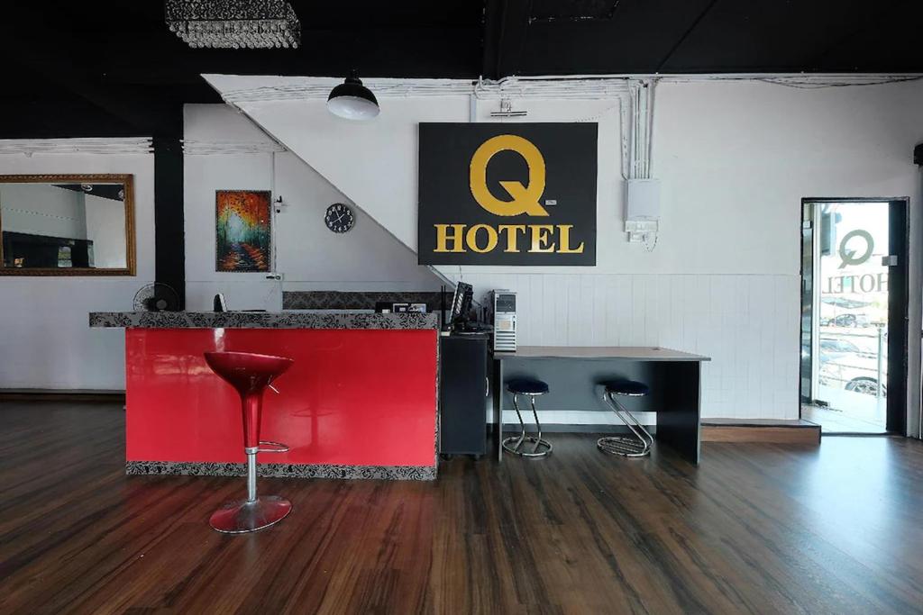 a hotel with a red counter and stools in a room at Q Hotel Temerloh in Temerloh