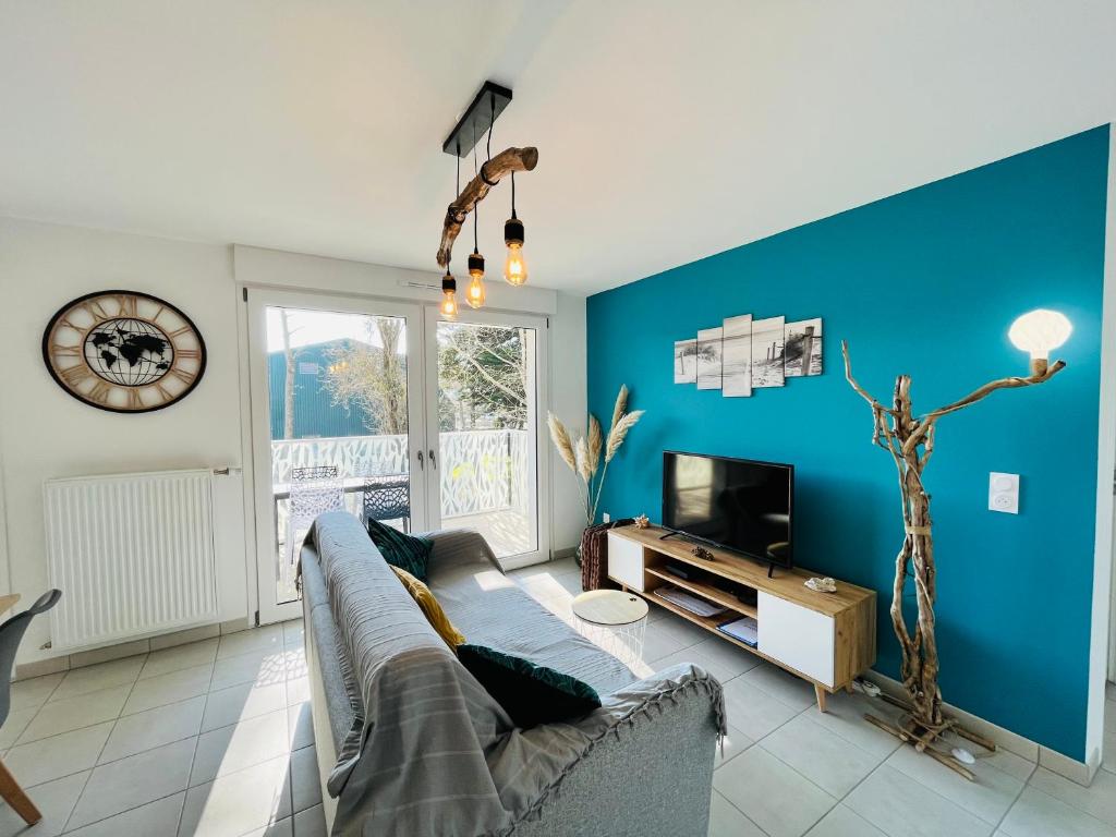 ein Wohnzimmer mit Sofa und Fernseher in der Unterkunft L'océan, T3 neuf 300m de la mer classé 3 étoiles in Saint-Jean-de-Monts