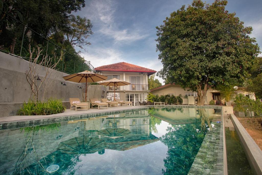 basen z parasolem i dom w obiekcie Gracian Villa w mieście Kandy