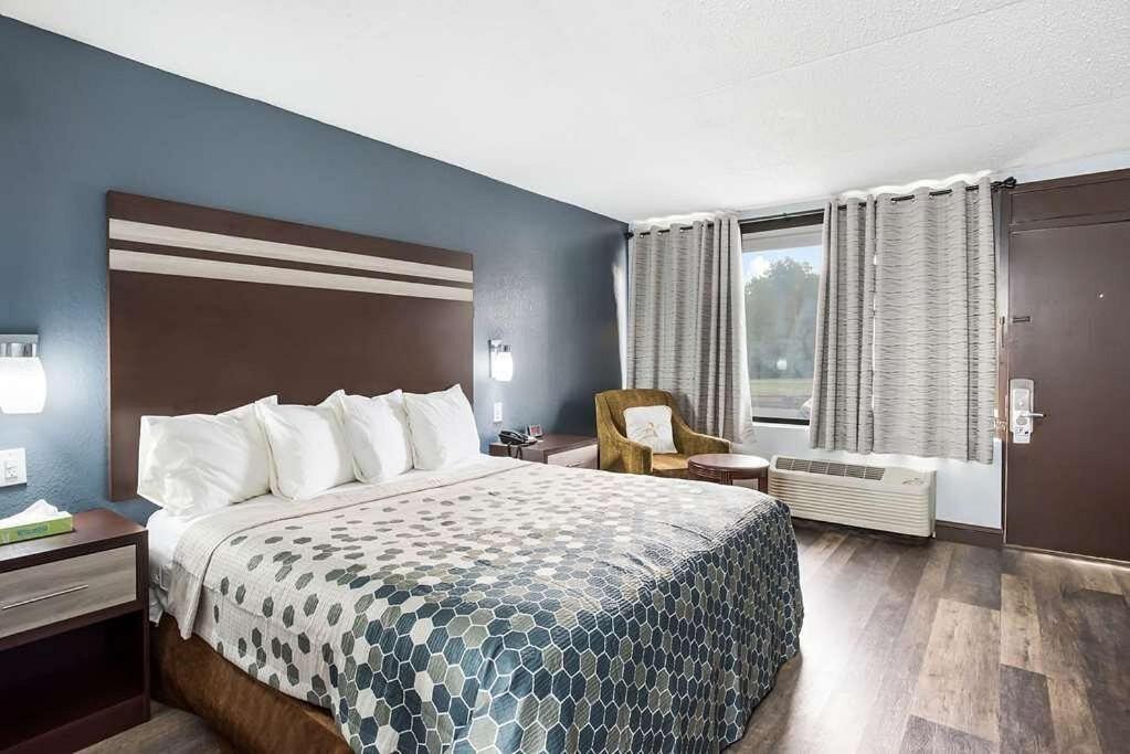 ein Hotelzimmer mit einem Bett und einem Stuhl in der Unterkunft Red Carpet Inn & Suites NJ-73 in Hammonton