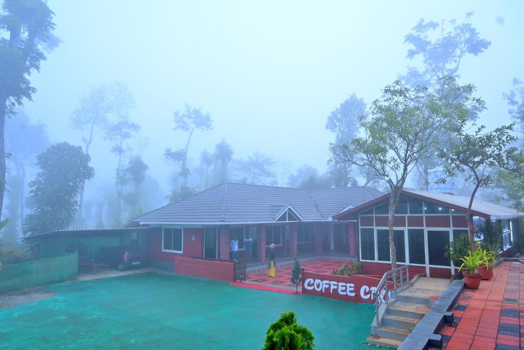 a house in the mist with a coffee shop at Coffee Crown Homestay - Water Falls, Trek, Home Food, Estate in Sakleshpur