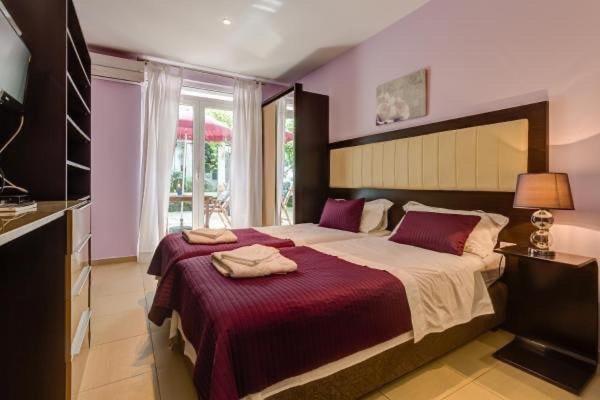 een slaapkamer met een groot bed en een rode deken bij Splendid Luxury Apartments in Budva