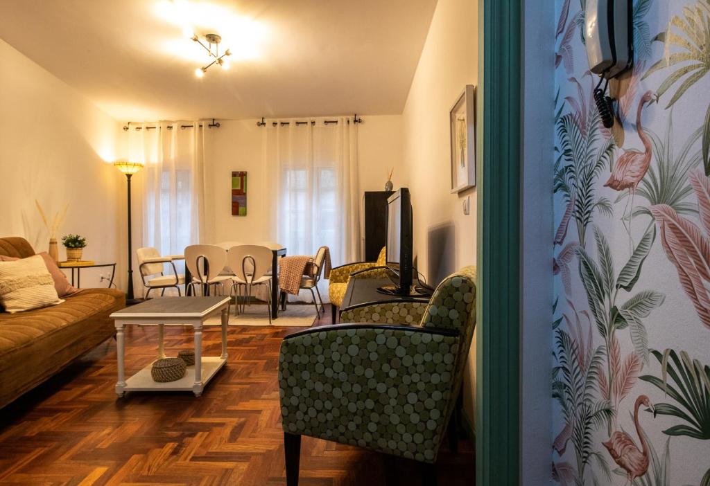 uma sala de estar com um sofá, uma mesa e cadeiras em O sete dos Soportais em Pontevedra