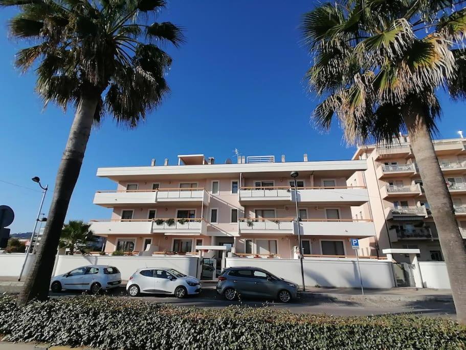 a large building with cars parked in front of it at Casa Rosa in Montesilvano