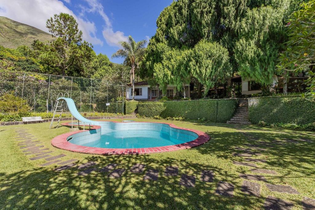 uma piscina com escorrega num quintal em Aconchegante Sítio na Serra com piscina em Itaipava em Itaipava