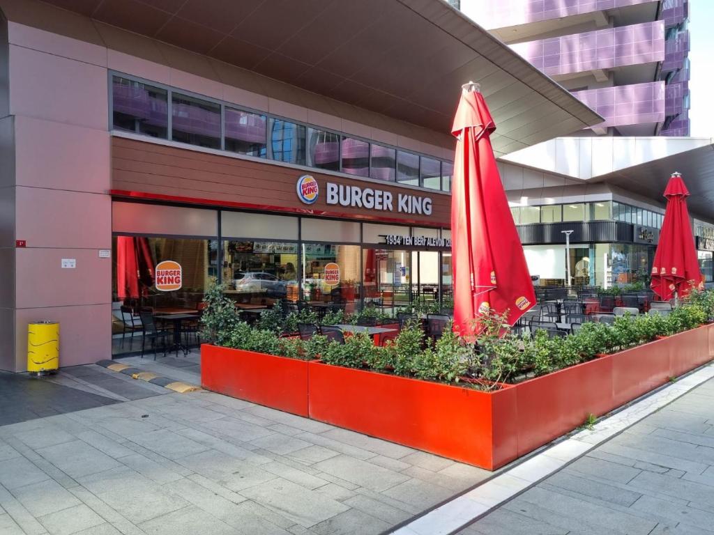 un restaurante Burger King con una sombrilla roja delante de él en Premium Stay 3 BDR Maslak 1453, en Estambul