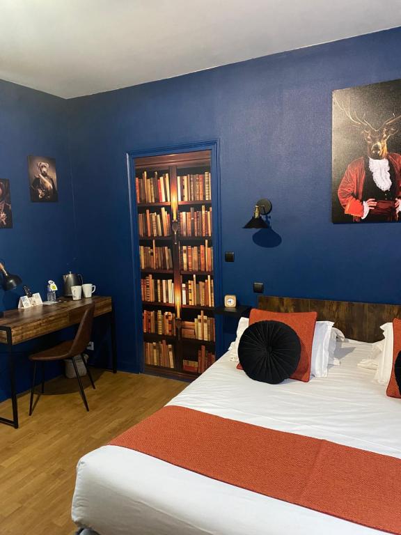 a bedroom with two beds and a desk and a book shelf at Logis Hôtel Le Cygne in Le Bugue