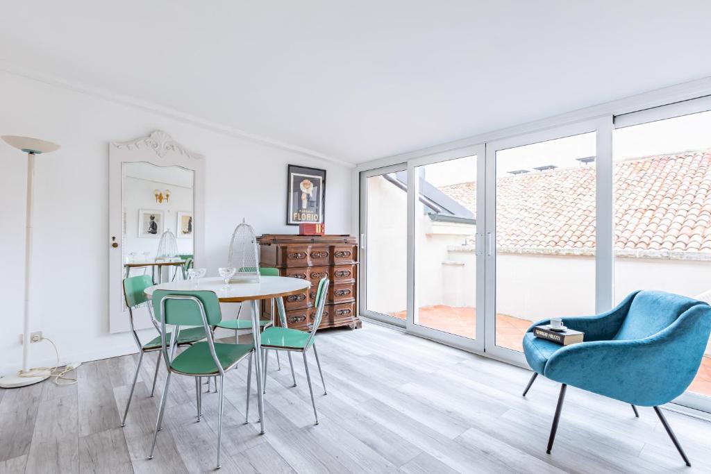 ein Wohnzimmer mit einem Tisch und Stühlen sowie ein Zimmer mit Fenstern in der Unterkunft The Roof Apartment - CityCenter - by HOST4U in Pavia