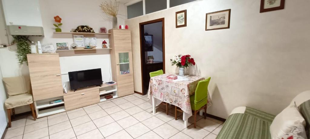 ein Wohnzimmer mit einem Tisch und einem TV in der Unterkunft Appartamento da Raffaella CIR O12133 CNI OOO39 in Varese