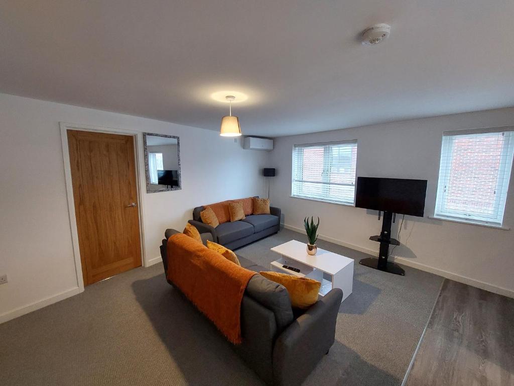 a living room with a couch and a flat screen tv at Apartment Balmoral Road in Northampton