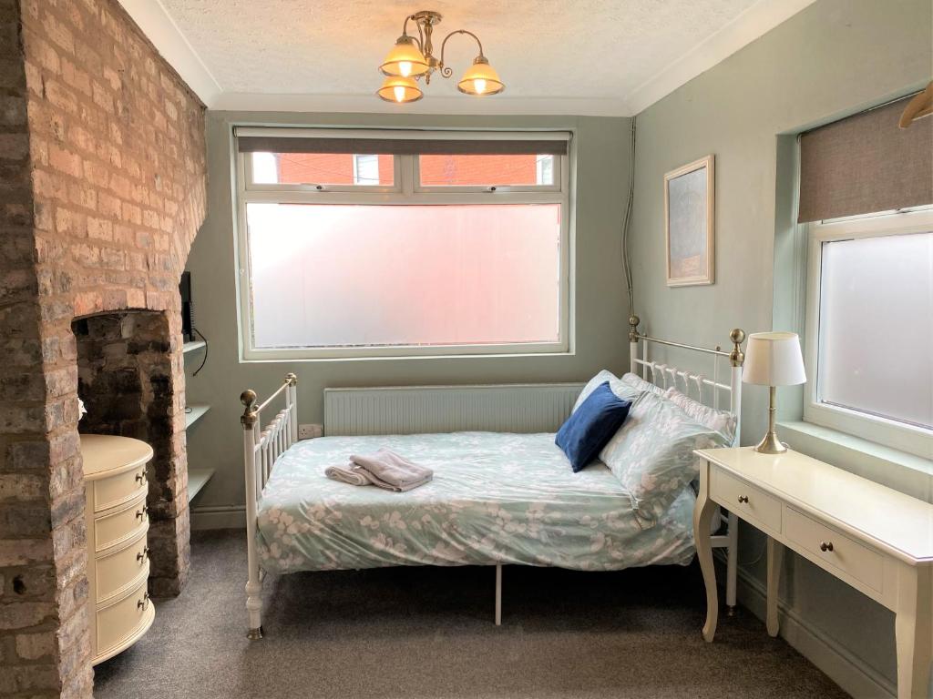 um pequeno quarto com uma cama e uma janela em Victorian Villa close to Liverpool City Centre em Liverpool