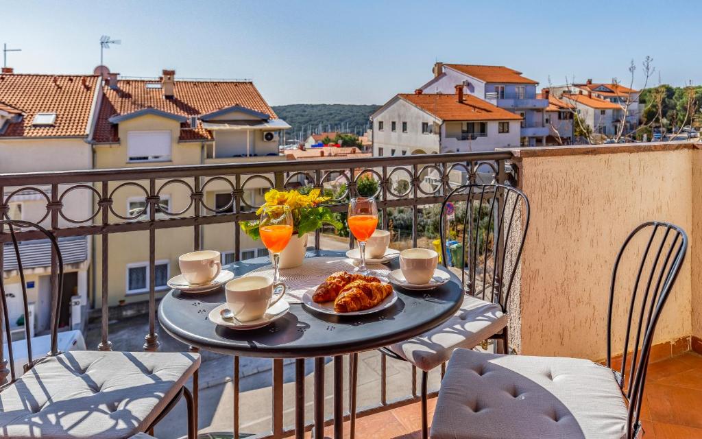 a table with a plate of food on a balcony at Apartment Green Pula, Family friendly, Comfortable, free parking and WiFi in Pula