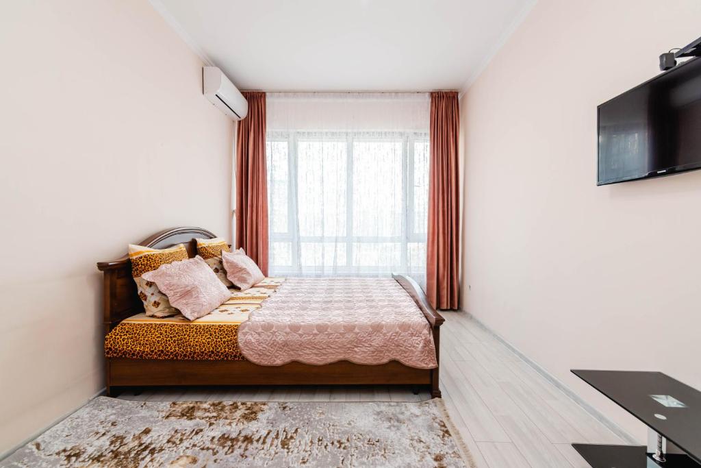 sypialnia z łóżkiem i oknem w obiekcie Element, 157 w mieście Ałma-Ata