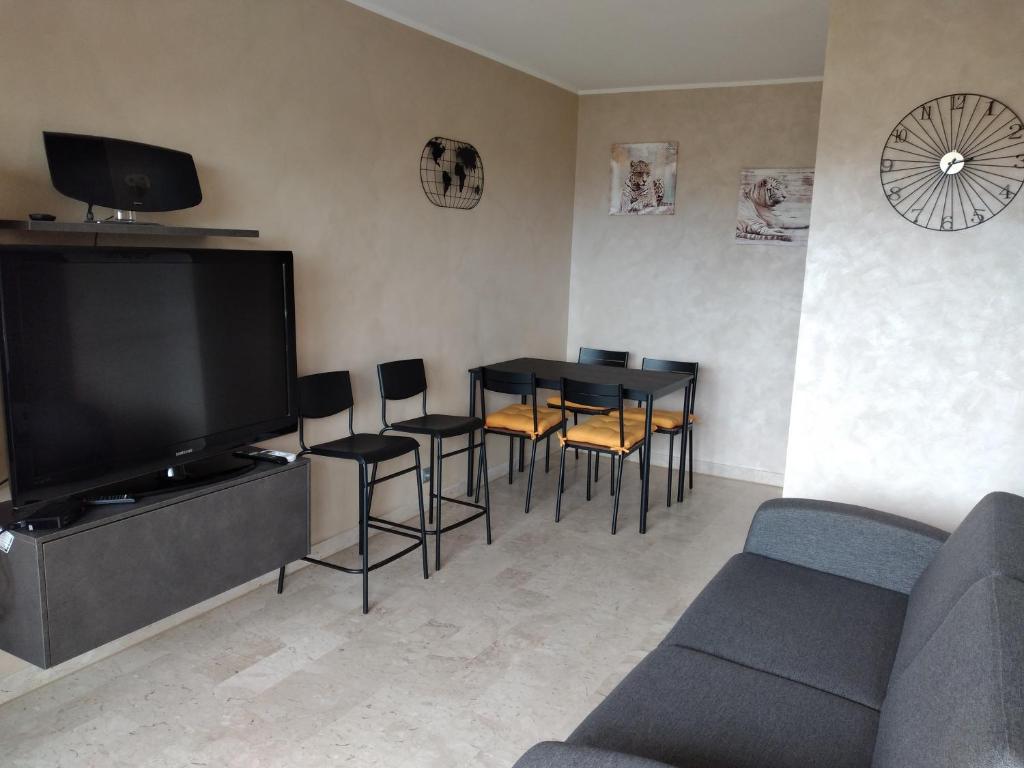 a living room with a tv and a table and chairs at Studio entièrement rénové coté plage avec garage in Roquebrune-Cap-Martin