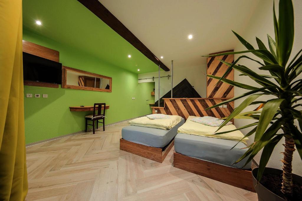 um quarto verde com duas camas e um vaso de plantas em Le Domaine du Verger, Chambres et SPA prive em Osenbach
