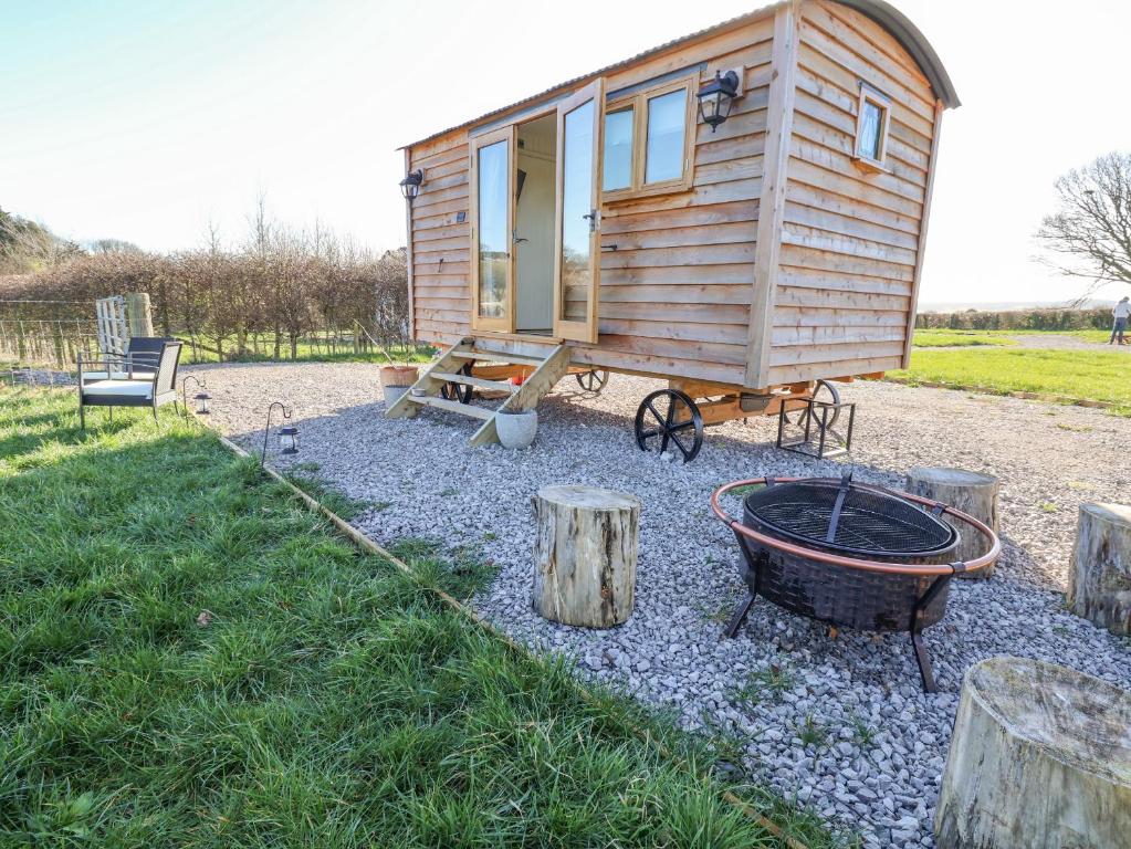 a tiny house with a fire pit in the yard at Cariad Bach in Rhyl