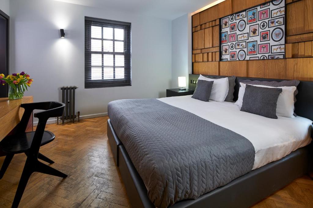 a bedroom with a bed with a wooden headboard and a desk at London Paddington Apartments in London
