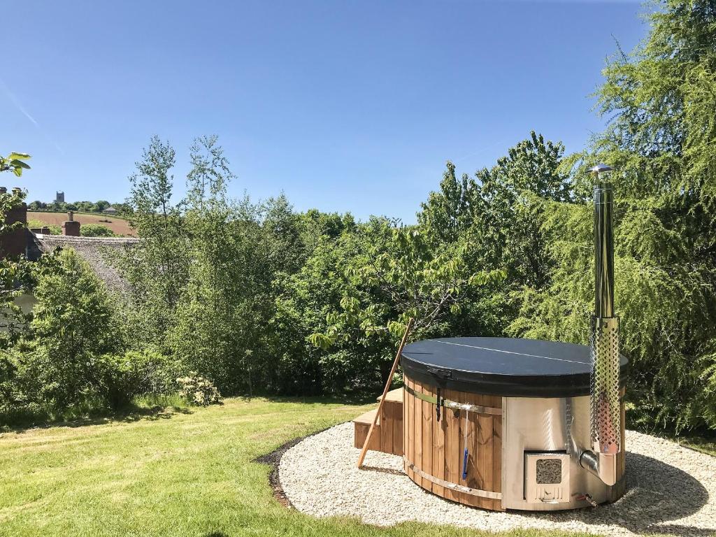 a barbecue grill in a yard with a grass field at The Cider Barn in Colebrooke