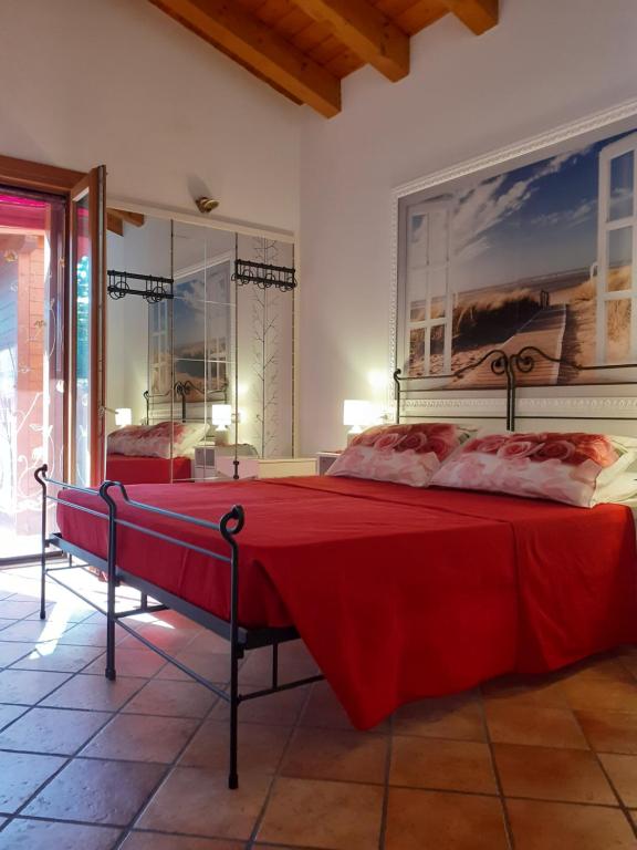 um quarto com 2 camas e uma colcha vermelha em B&B Casa di Chiara em San Michele al Tagliamento